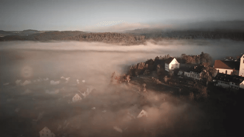 Timelapse stock footage of fog rolling over a village at sunrise ​