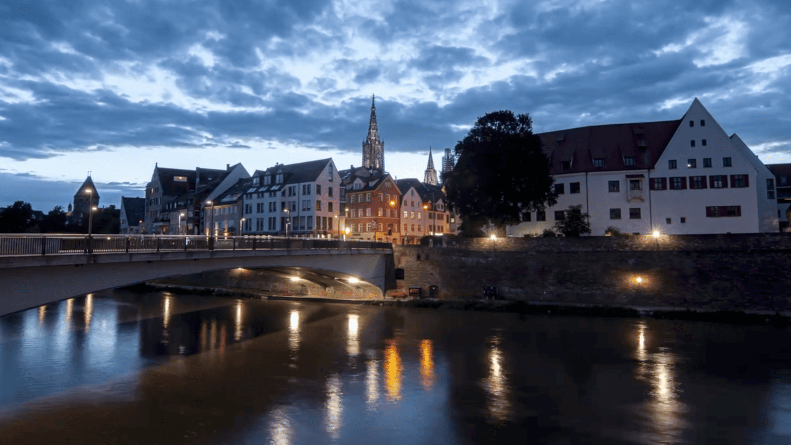 Timelapse Interval Guide: blue hour timelapse of a riverside city with church spires and building lights reflecting on the water